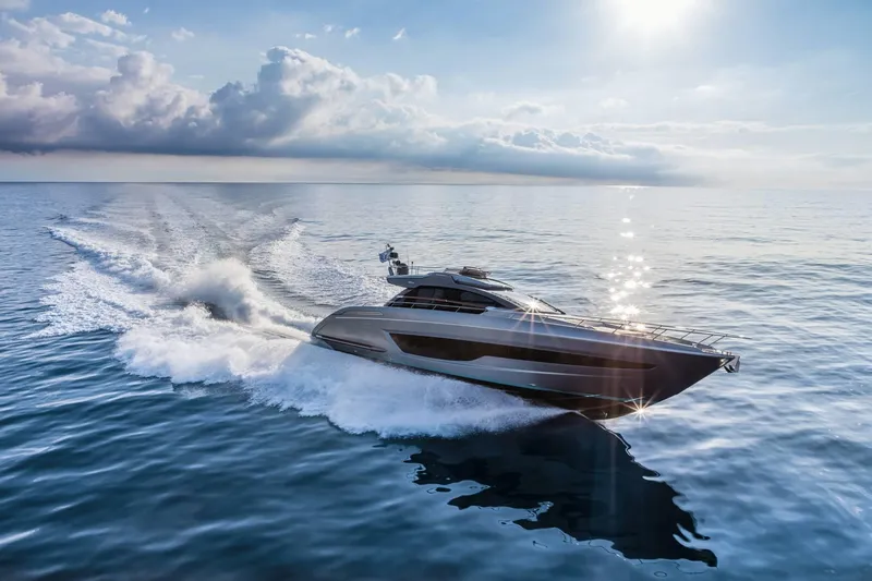 Slide: The Image of 2024 Riva 66' Ribelle yacht cruising on open sea under a bright sky. - 2