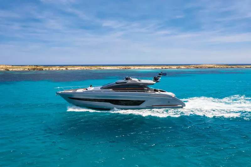 Slide: The Image of 2024 Riva 66' Ribelle yacht cruising on clear blue waters. - 8