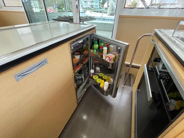 Slide: The Image of Lagoon 620 yacht kitchen with open fridge, model year 2014. - 19