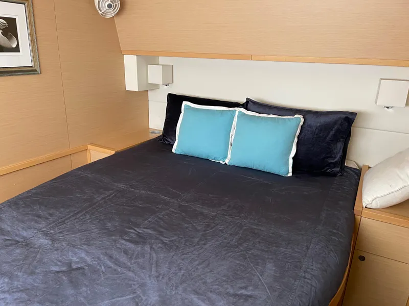 Slide: The Image of Interior of Lagoon 620 yacht, cozy bedroom with blue pillows, 2014 model. - 39