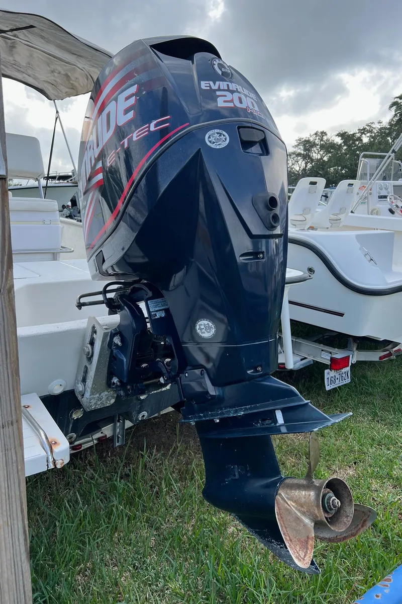 Slide: The Image of 2000 Triton 23 Tunnel boat with Evinrude outboard motor on grass. - 11