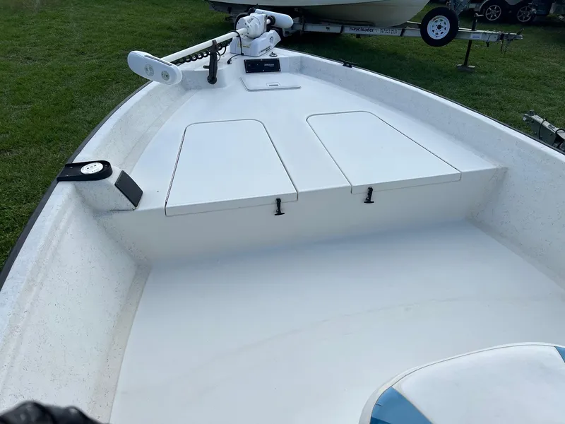 Slide: The Image of 2000 Triton 23 Tunnel boat interior with storage compartments and trolling motor. - 2