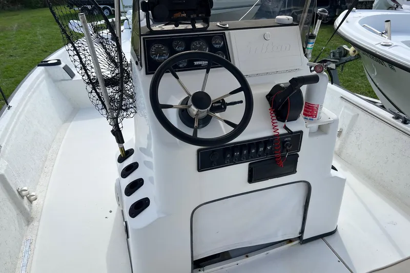 Slide: The Image of 2000 Triton 23 Tunnel boat cockpit with steering wheel and control panel. - 5