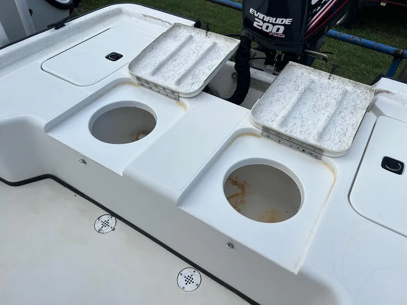 Slide: The Image of 2000 Triton 23 Tunnel boat with Evinrude 200 engine, featuring dual storage compartments. - 8