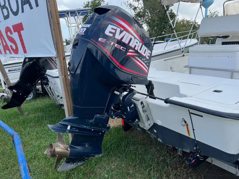 Slide: The Image of 2000 Triton 23 Tunnel boat with Evinrude E-TEC outboard motor displayed outdoors. - 9