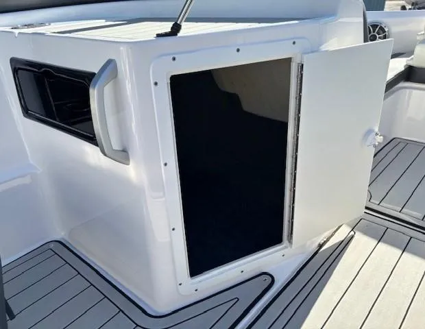 Slide: The Image of 2020 Yamaha Boats 195S storage compartment with open door on deck. - 14