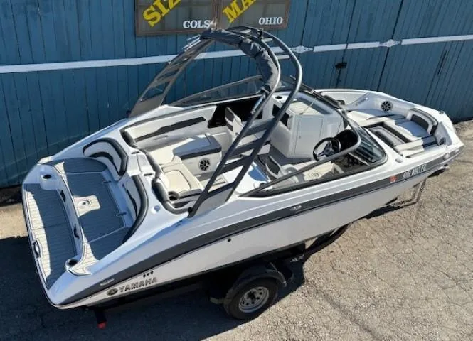 Slide: The Image of 2020 Yamaha Boats 195S, white and black, on trailer, parked outdoors. - 7