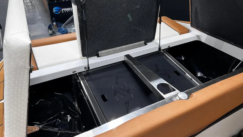 Slide: The Image of 2024 Supreme S220 boat storage compartment with open lids and cushioned seating. - 15