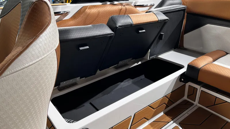 Slide: The Image of 2024 Supreme S220 boat interior with open storage compartment, featuring brown and black seating. - 17