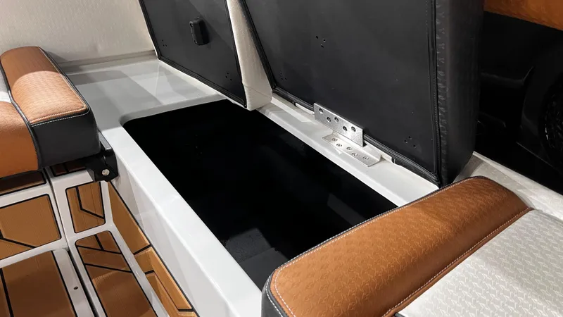 Slide: The Image of 2024 Supreme S220 boat interior storage compartment with cushioned seating. - 18