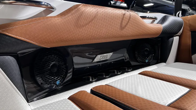 Slide: The Image of 2024 Supreme S220 boat interior with premium brown and white seating and built-in speakers. - 20
