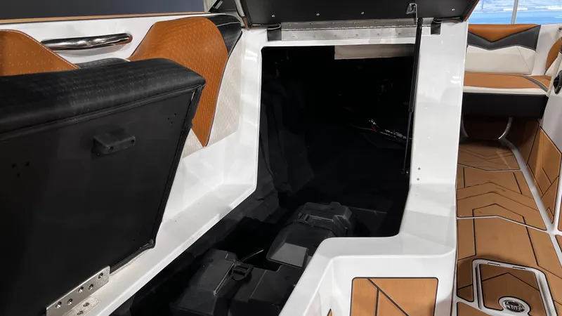 Slide: The Image of 2024 Supreme S220 boat interior with open storage compartment and stylish seating. - 23