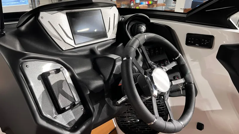 Slide: The Image of 2024 Supreme S220 boat dashboard with steering wheel and digital display. - 26