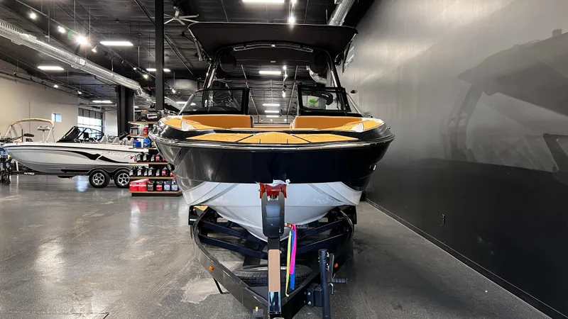 Slide: The Image of 2024 Supreme S220 boat in showroom, front view, sleek design, black and yellow accents. - 3
