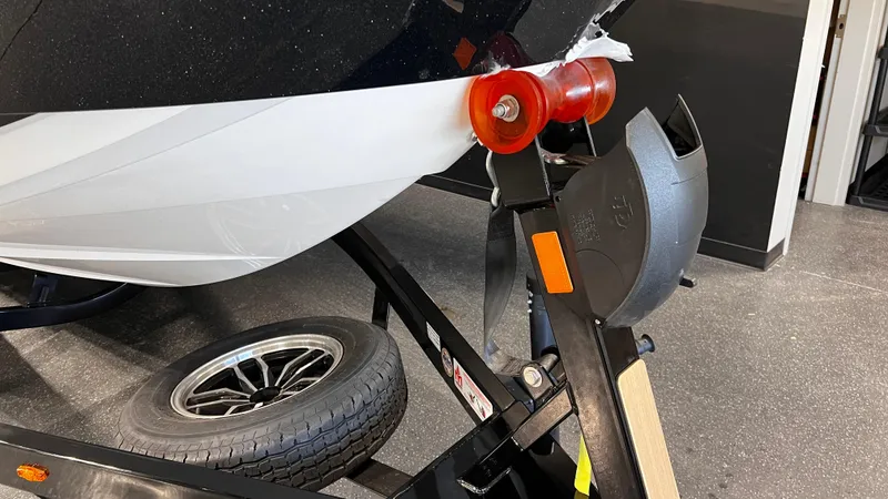Slide: The Image of 2024 Supreme S220 boat on trailer, close-up of bow and wheel. - 7