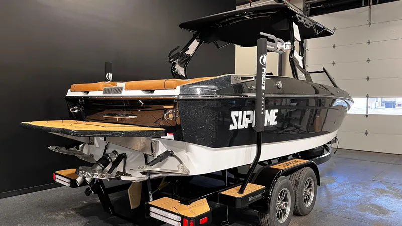 Slide: The Image of 2024 Supreme S220 boat on trailer in showroom, black and white design. - 8