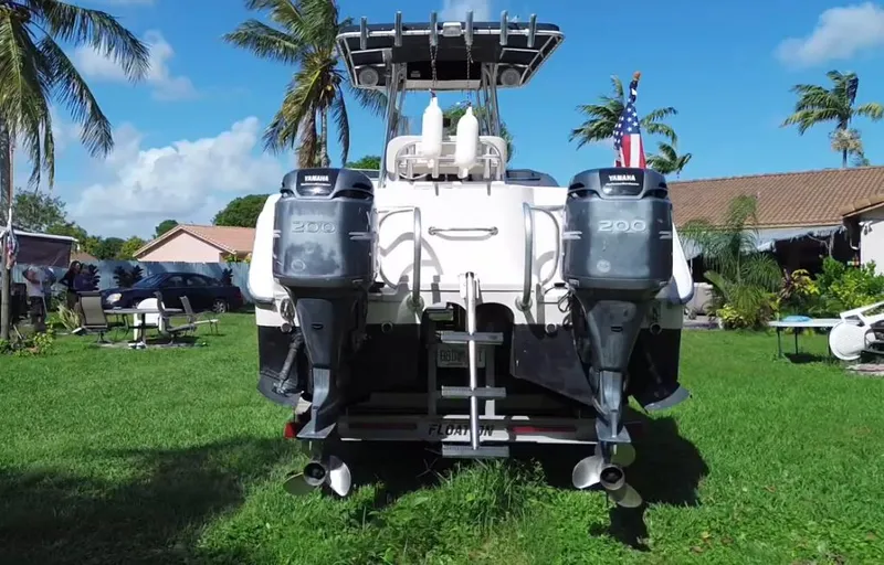 Slide: The Image of 1999 Grady-White X-26 Tiger Cat boat with dual Yamaha engines, parked on grass. - 12