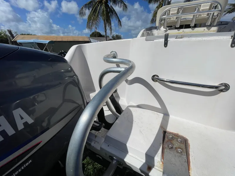 Slide: The Image of 1999 Grady-White X-26 Tiger Cat boat with Yamaha engine, docked under palm trees. - 19