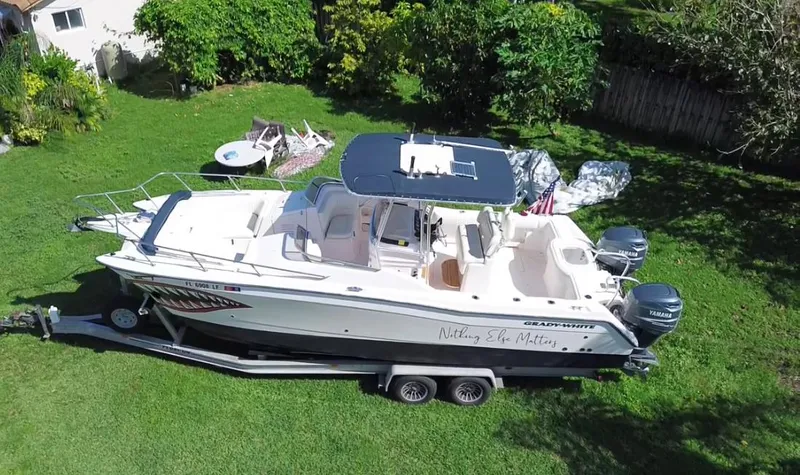 Slide: The Image of 1999 Grady-White X-26 Tiger Cat boat on trailer in grassy yard. - 2