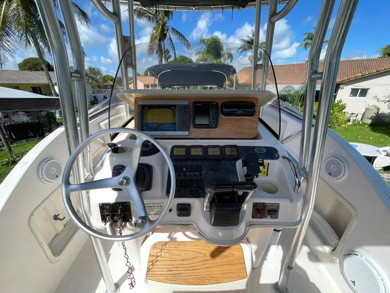 Slide: The Image of 1999 Grady-White X-26 Tiger Cat boat dashboard with steering wheel and navigation equipment. - 21