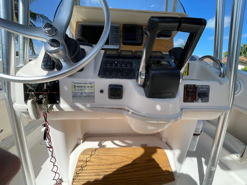 Slide: The Image of 1999 Grady-White X-26 Tiger Cat boat dashboard with steering wheel and controls. - 25