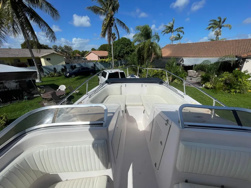 Slide: The Image of 1999 Grady-White X-26 Tiger Cat boat with white seating, parked in a tropical backyard. - 29