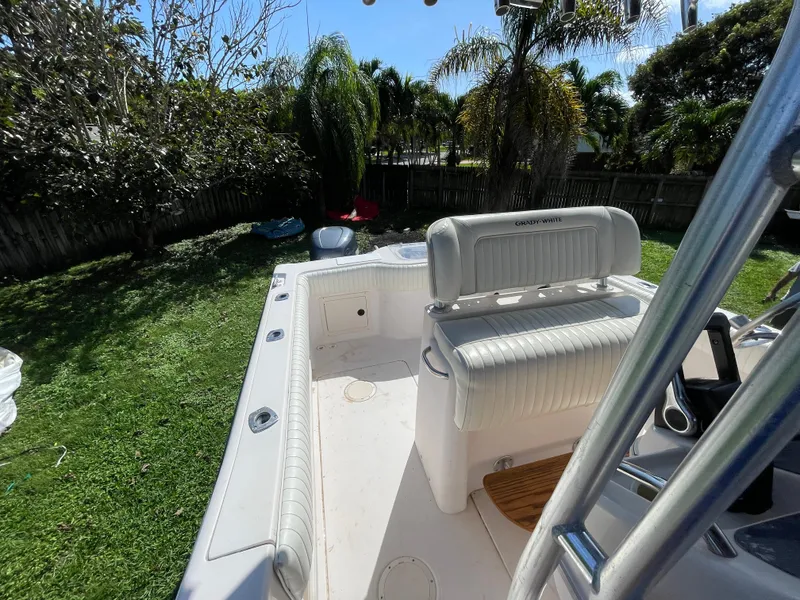 Slide: The Image of 1999 Grady-White X-26 Tiger Cat boat interior with seating, in a sunny backyard setting. - 48