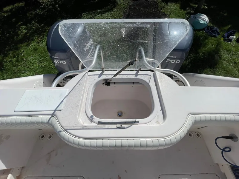 Slide: The Image of 1999 Grady-White X-26 Tiger Cat boat with dual 200 engines, featuring a central storage compartment. - 52