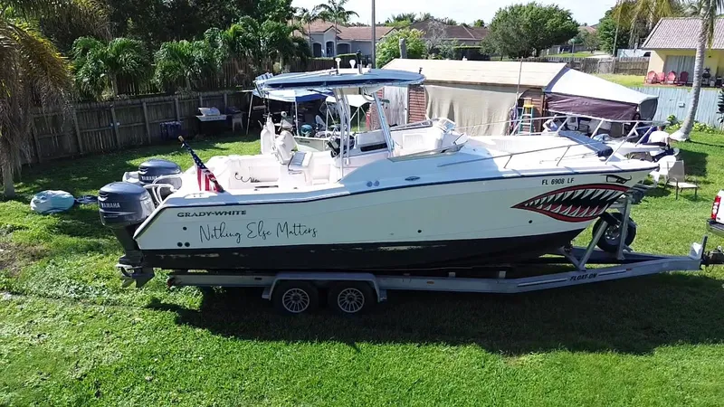 Slide: The Image of 1999 Grady-White X-26 Tiger Cat boat on trailer in backyard setting. - 7