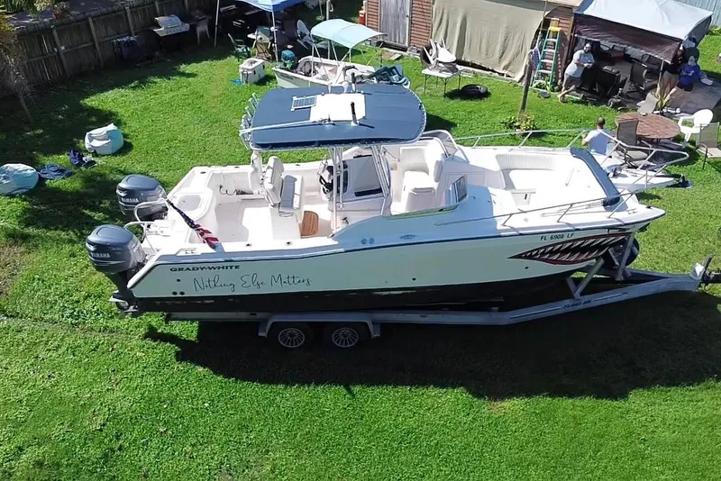 Slide: The Image of 1999 Grady-White X-26 Tiger Cat boat on trailer in grassy yard. - 8