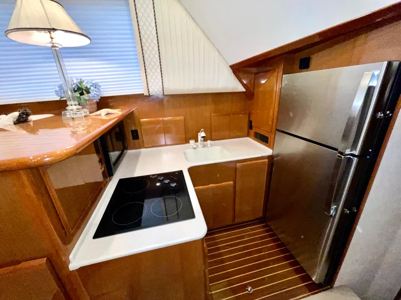 Slide: The Image of Luxurious yacht kitchen with modern appliances, wooden cabinetry, and sleek countertops in a 2001 Post 50 Convertible. - 19