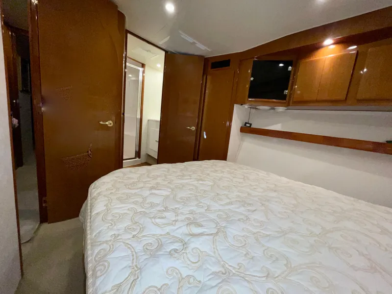 Slide: The Image of Luxurious bedroom interior of 2001 Post 50 Convertible yacht with wood cabinetry and cozy bedding. - 24