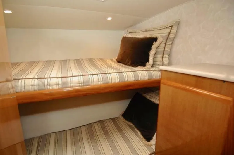 Slide: The Image of Cozy cabin interior of 2001 Post 50 Convertible with striped bedding and wooden accents. - 30
