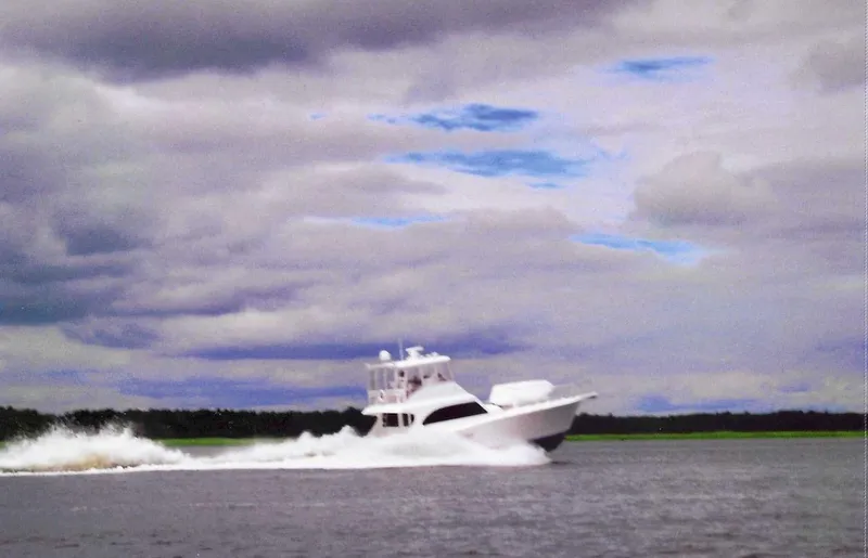 Slide: The Image of 2001 Post 50 Convertible yacht cruising on open water under cloudy skies. - 38