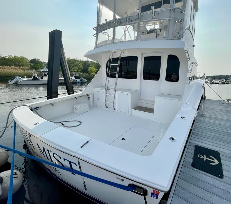 Slide: The Image of 2001 Post 50 Convertible yacht docked at marina, featuring spacious deck and upper helm. - 43