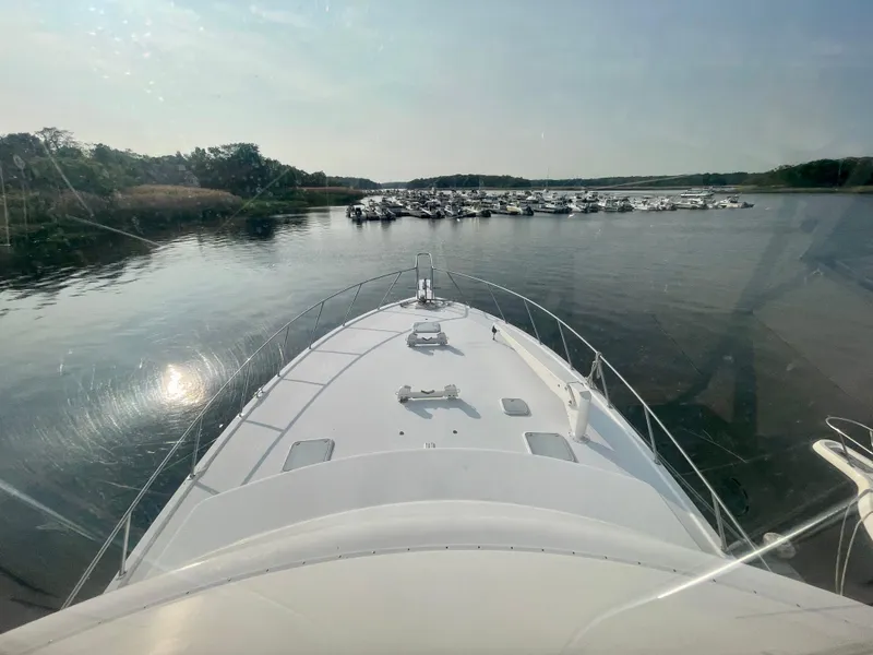 Slide: The Image of Bow view of 2001 Post 50 Convertible yacht approaching marina with docked boats. - 44