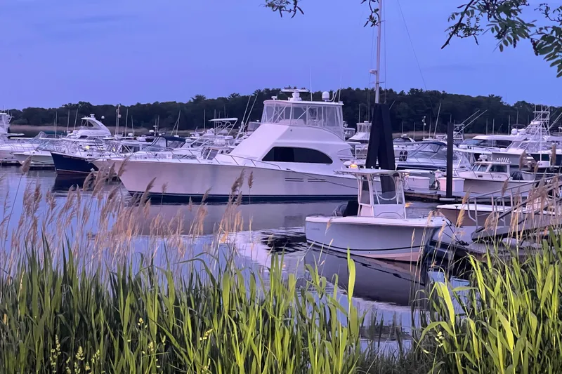 Slide: The Image of Boats docked at a marina, featuring a 2001 Post 50 Convertible yacht. - 54