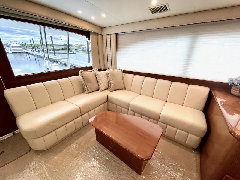 Slide: The Image of Luxurious interior of a 2001 Post 50 Convertible yacht with beige seating and wooden table. - 7