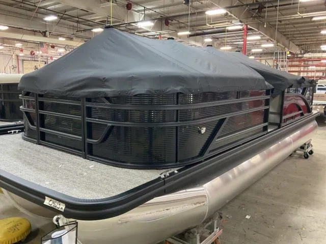 Slide: The Image of 2025 Bennington 23 SL pontoon boat with cover in a warehouse setting. - 12