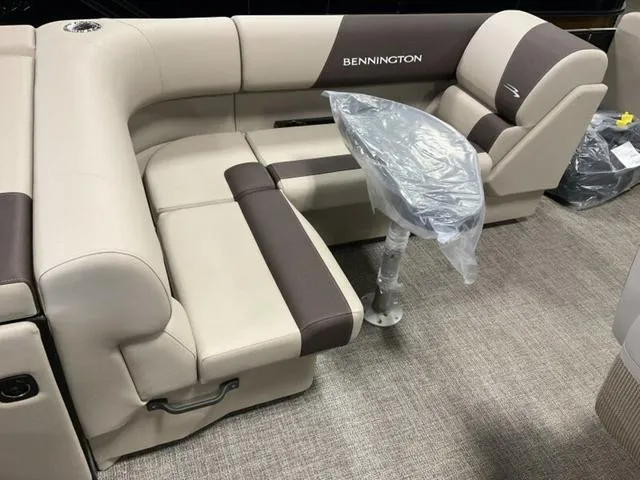 Slide: The Image of 2025 Bennington 23 SL boat interior with beige and brown seating and a covered table. - 4