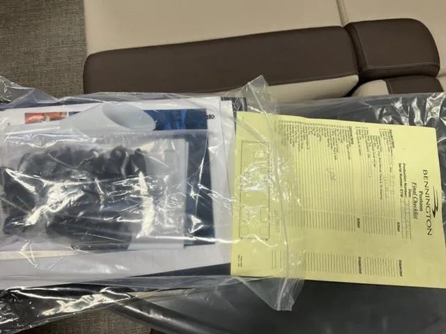 Slide: The Image of Bennington 23 SL 2025 documents in plastic bag on boat seat. - 8