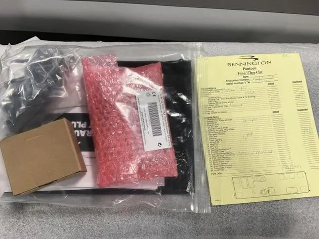 Slide: The Image of Bennington 23 SSB 2025 paperwork and checklist with packaging materials. - 13