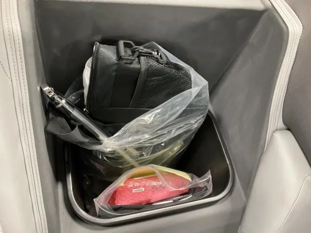 Slide: The Image of Storage compartment in a 2025 Bennington 23 SSB with bags and items. - 15