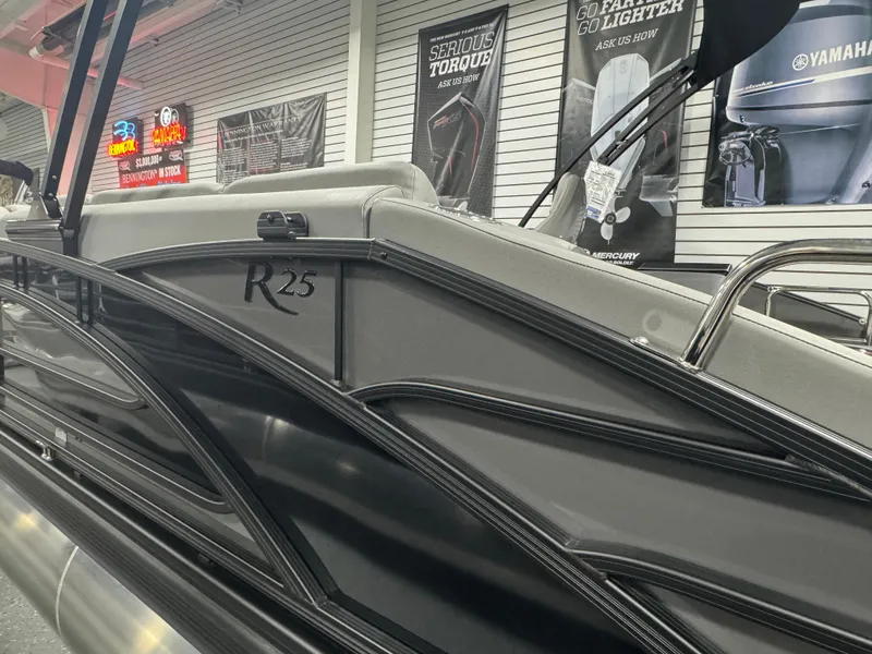 Slide: The Image of 2025 Bennington 25 RSB pontoon boat in showroom, showcasing sleek design and modern features. - 22