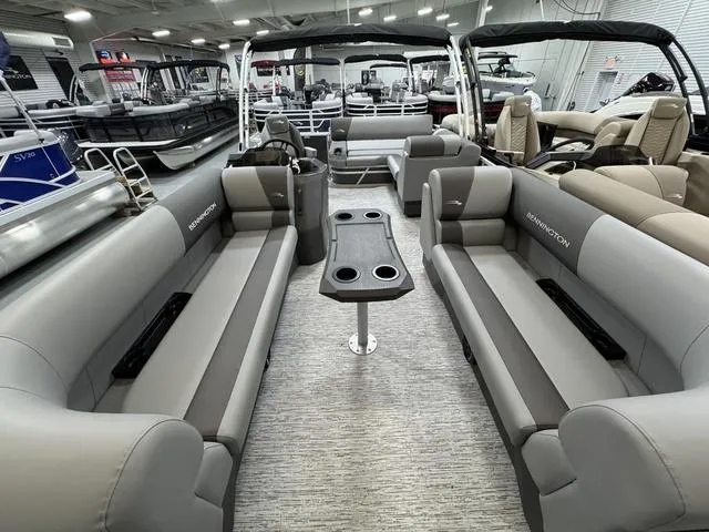 Slide: The Image of 2025 Bennington 22 SSB pontoon boat with black cover in a warehouse setting. - 12