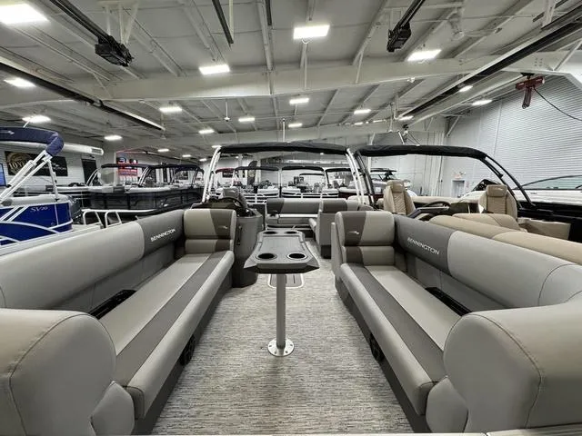 Slide: The Image of 2025 Bennington 22 SSB pontoon boat with black cover in a warehouse setting. - 13