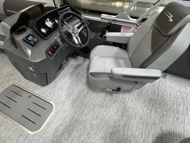Slide: The Image of 2025 Bennington 22 SSB pontoon boat in showroom, sleek design, black and silver finish. - 15