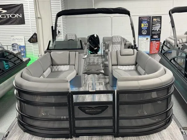Slide: The Image of 2025 Bennington 25 RFBSE pontoon boat displayed in a showroom with nautical decor. - 1
