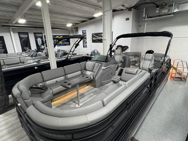 Slide: The Image of 2025 Bennington 25 RFBSE pontoon boat displayed indoors with sleek design and modern features. - 2