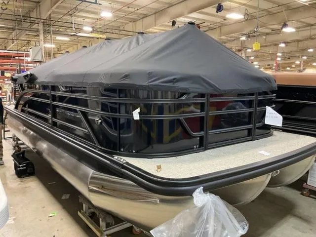 Slide: The Image of 2025 Bennington 22 SSR pontoon boat with cover in a warehouse setting. - 13